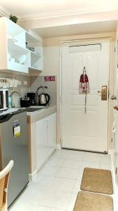 a kitchen with a white door and a white floor at Beloved's Homestay in Iruhin
