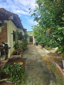 a path leading to a house with trees and plants at Casa para Carnaval in Olinda