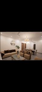 a living room with two couches and a table at The carmine house-Private 4 BHk luxury retreat in sector 132, Noida in Noida