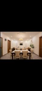 a dining room with tables and chairs and a chandelier at The carmine house-Private 4 BHk luxury retreat in sector 132, Noida in Noida