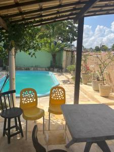 a patio with a table and chairs and a pool at Casa para Carnaval in Olinda