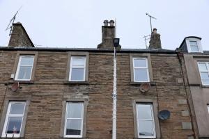 a brick building with white windows and two chimneys at The Coastal Haven, Broughty Ferry in Dundee