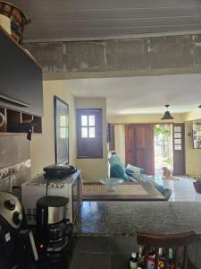 a kitchen with a stove and a living room at Casa para Carnaval in Olinda