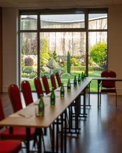 a long table with green bottles on it with red chairs at Hotel Olympic Spa & Wellness in Ustroń +66 photos