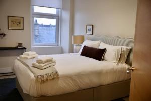 a bedroom with a bed with towels on it at The Coastal Haven, Broughty Ferry in Dundee