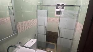 a bathroom with a toilet and a glass shower stall at Cozy House in Wadi Musa +142 photos