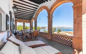 an outdoor patio with white furniture and a view of the water at Es Clot in Alcudia