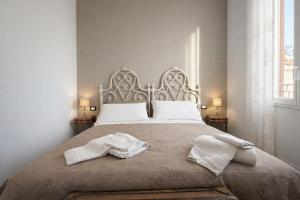 a bedroom with a bed with two towels on it at Casa Danilo Sanremo Centro - a 100m dalla Spiaggia in Sanremo