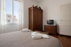 a bedroom with a bed and a dresser and a tv at Casa Danilo Sanremo Centro - a 100m dalla Spiaggia in Sanremo +5 photos