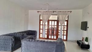 a living room with two couches and a large window at Malindi Sunset Apartments in Malindi