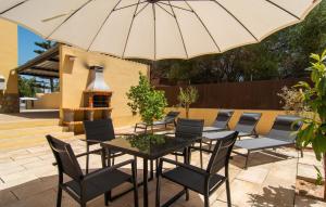 a patio with a table and chairs and an umbrella at Calamari 7 in Portocolom