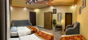 a bedroom with two beds and two chairs at Cozy House in Wadi Musa