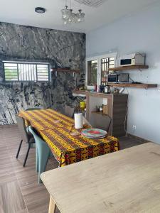 a dining room with a table and a stone wall at keur Baye fall fall saly in Sali Nianiaral