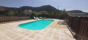 a small swimming pool in a backyard with a fence at Les Eucalyptus in Vesseaux
