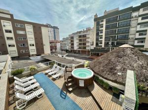 an outdoor deck with a hot tub and lounge chairs at CAPÃO Da CANOA MAR HOTEL in Capão da Canoa +60 photos