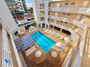 an aerial view of a building with a swimming pool at CAPÃO Da CANOA MAR HOTEL in Capão da Canoa