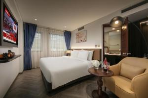 a hotel room with a bed and a table and a couch at Sora Hotel Hanoi in Hanoi