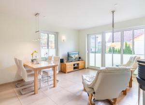 a living room with a table and chairs and a television at Haus Hanse in Korswandt