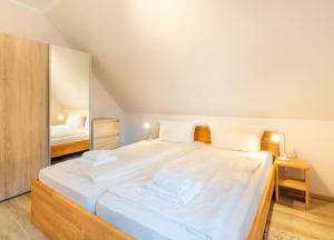 a large white bed in a room with a mirror at Haus Hanse in Korswandt