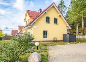 a yellow house with a red roof at Haus Hanse in Korswandt