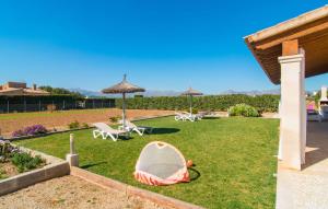 a garden with chairs and umbrellas on the grass at Can Ferrer in Alcudia