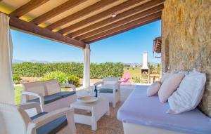 a patio with a couch and chairs and a stone wall at Can Ferrer in Alcudia