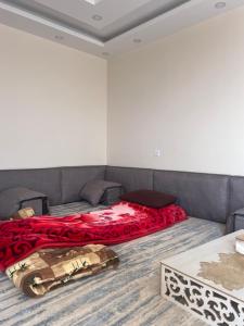 a bedroom with a bed with a red blanket at Local experience in El Quweira