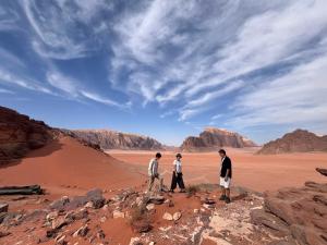 three men standing on a rock in the desert at Local experience in El Quweira