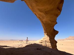 a person standing on a rock in the desert at Local experience in El Quweira