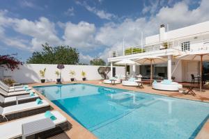 a villa with a swimming pool and a house at Villa Mara- Close Playa den Bossa beach in Sant Jordi