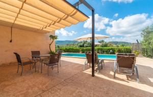 a patio with a table and chairs and a pool at Clonenell in Canyamel