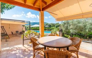 a patio with a table and chairs and a pool at Clonenell in Canyamel