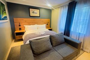 a bedroom with a bed and a couch at The Hide on Aston-Sandton in Johannesburg +66 photos