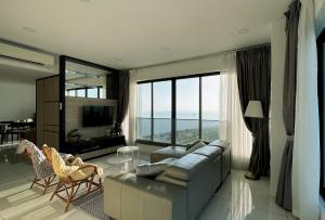 a living room with a couch and a large window at Sunrise Gurney Georgetwon in George Town