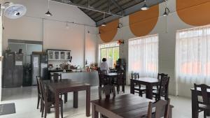 a restaurant with tables and chairs and a person in the kitchen at Nos Vetra Resort in Phú Quốc