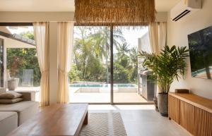 a living room with a table and a large window at Ocean Villa in Ko Phangan