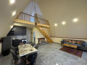 a living room with a staircase and a couch at Boss House in Quba