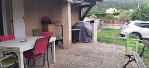 a table and chairs on a patio with a car at Les Eucalyptus in Vesseaux