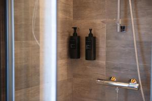 two bottles ofodorizers are on the wall of a shower at Terrazza Retica in Piateda