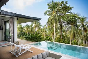 a villa with a swimming pool and palm trees at Ocean Villa in Ko Phangan