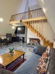 a living room with a couch and a staircase at Boss House in Quba