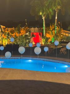 a swimming pool at night with chairs and tables at Windsor House in Secunderabad
