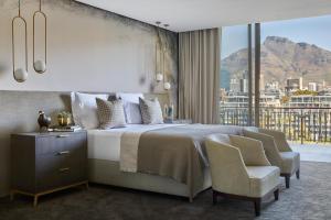 a bedroom with a bed and a large window at One&Only Cape Town in Cape Town