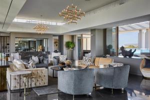 a living room with furniture and a chandelier at One&Only Cape Town in Cape Town
