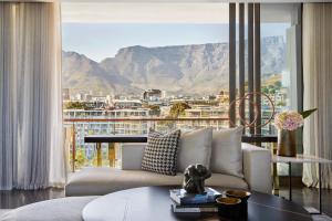 a living room with a couch and a large window at One&Only Cape Town in Cape Town +116 photos