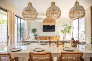 a dining room with a table with chairs and chandeliers at Ocean Villa in Ko Phangan