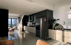 a kitchen with black cabinets and a stainless steel refrigerator at Sunrise Gurney Georgetwon in George Town