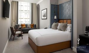 a bedroom with a large bed and a living room at The Parkgate Hotel in Cardiff