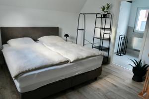 a bedroom with a large bed with white sheets at Altstadt Apartment Chalet in Haltern