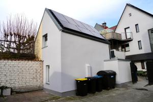 a white house with four trash cans in front of it at Altstadt Apartment Chalet in Haltern